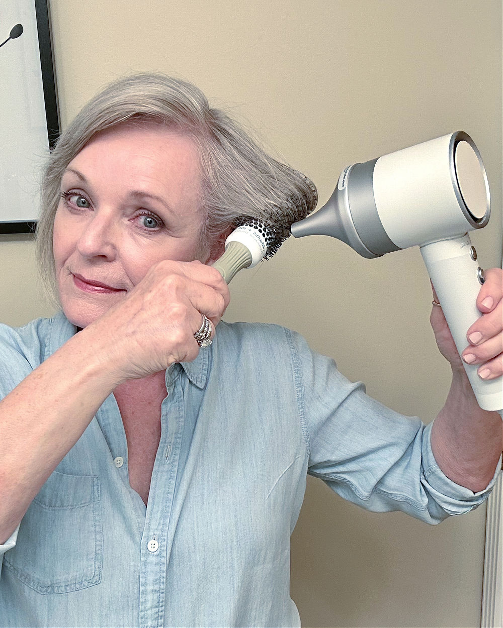 a older adult using a hair dryer